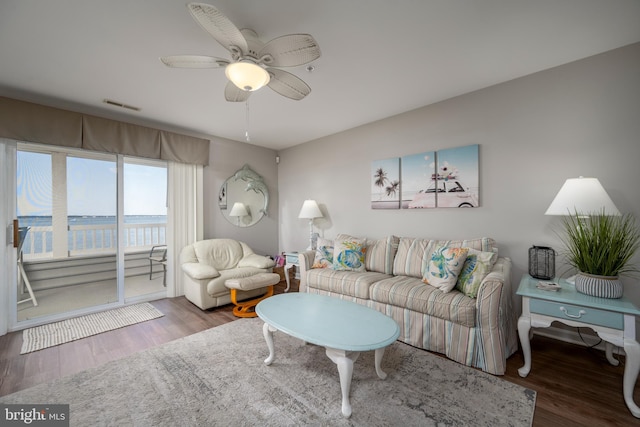 living room featuring a water view, dark hardwood / wood-style floors, and ceiling fan