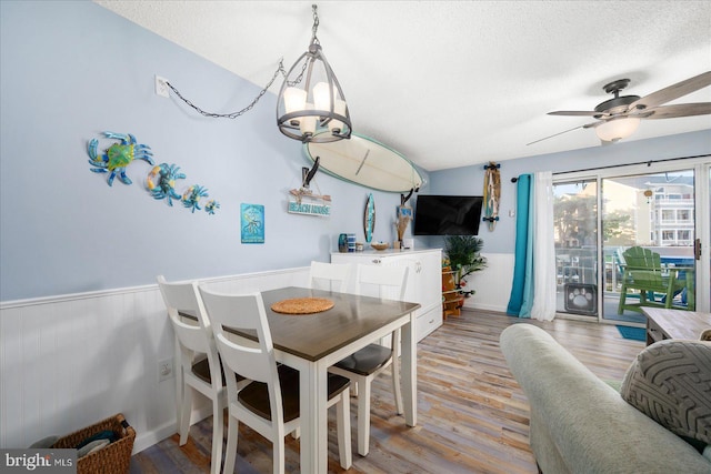 dining room with a textured ceiling, light wood-type flooring, and ceiling fan