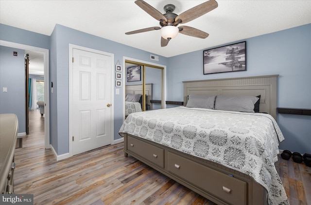 bedroom with light hardwood / wood-style flooring, a closet, and ceiling fan