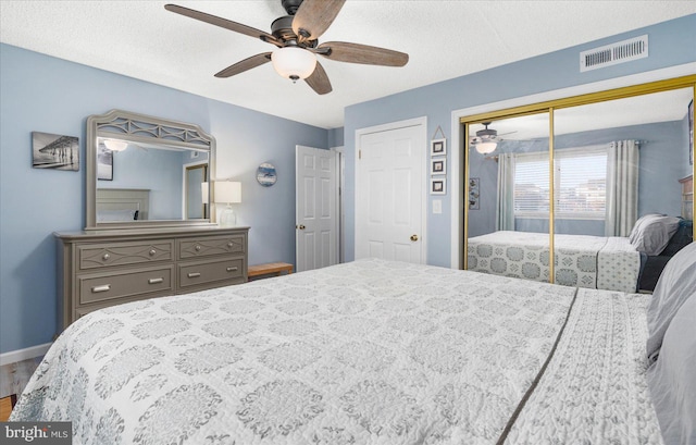 bedroom with a textured ceiling, hardwood / wood-style flooring, a closet, and ceiling fan