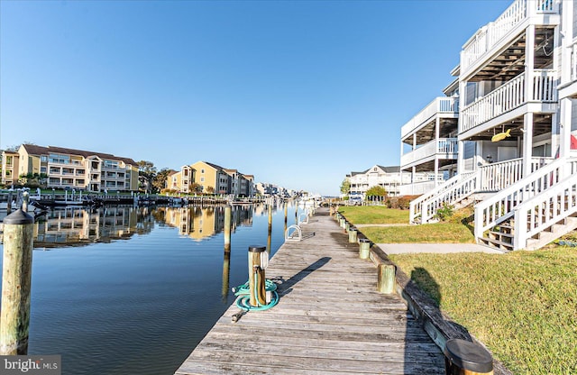 dock area with a deck with water view and a lawn