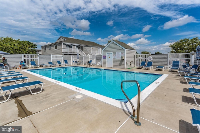 view of swimming pool with a patio and an outbuilding