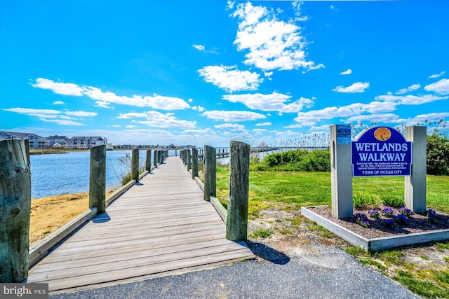 dock area with a water view and a lawn