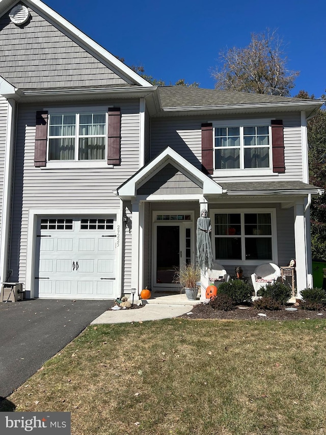 view of property featuring a front lawn and a garage