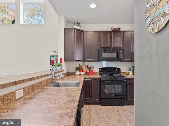 29225 Shady Creek Ln Unit 29, Dagsboro, DE 19939 - kitchen featuring light wood-style flooring, light countertops, black appliances, dark brown cabinets, and a sink