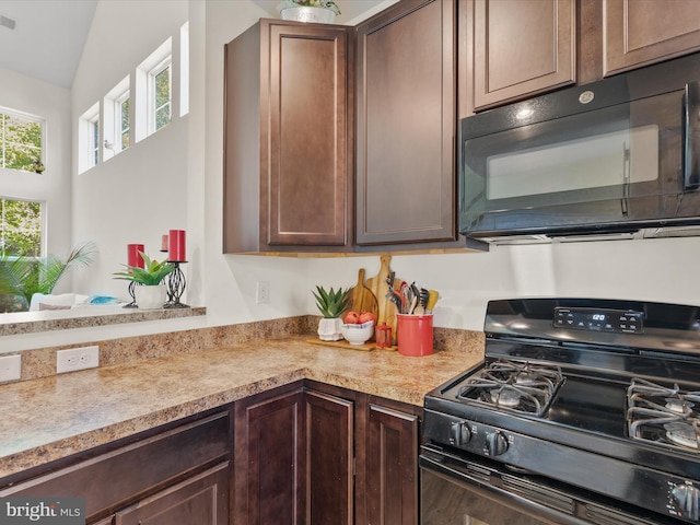 kitchen with lofted ceiling, black appliances, and dark brown cabinets