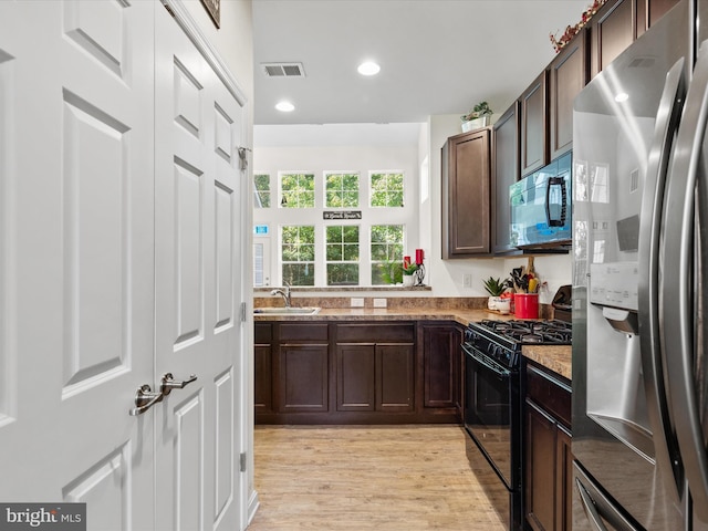 kitchen featuring light hardwood / wood-style floors, appliances with stainless steel finishes, sink, and dark brown cabinets