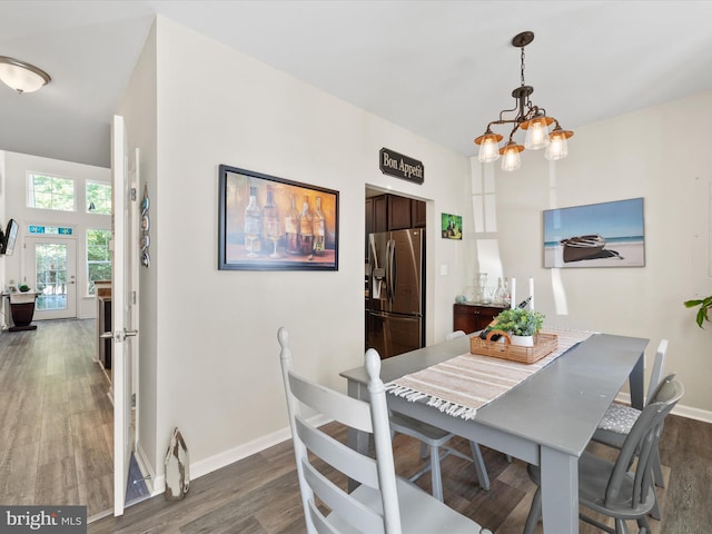 dining space with an inviting chandelier and dark hardwood / wood-style flooring