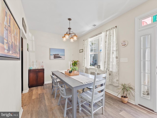 dining area featuring light hardwood / wood-style flooring and an inviting chandelier