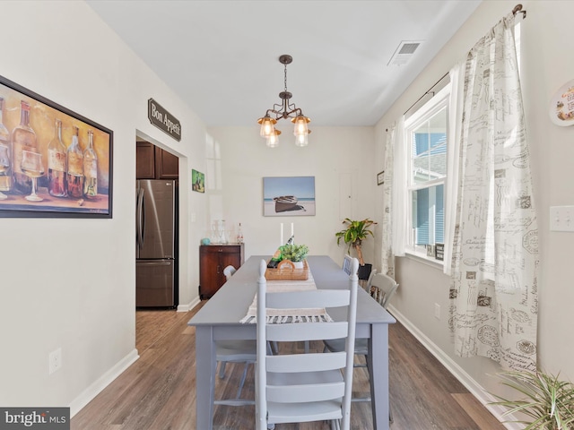 dining area featuring a notable chandelier and dark hardwood / wood-style flooring