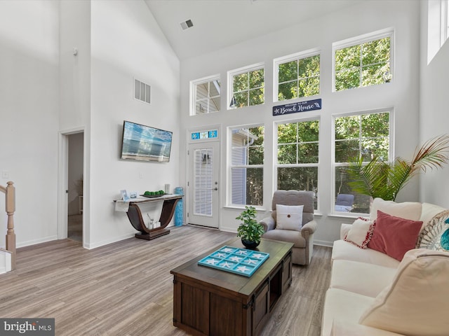 living room featuring light hardwood / wood-style floors and high vaulted ceiling