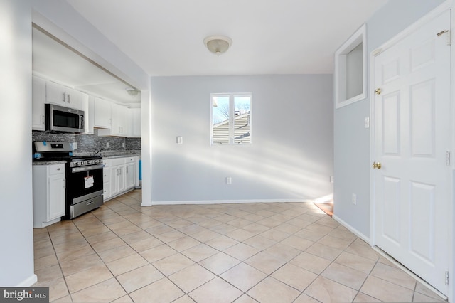 kitchen with white cabinetry, tasteful backsplash, appliances with stainless steel finishes, and light tile patterned floors