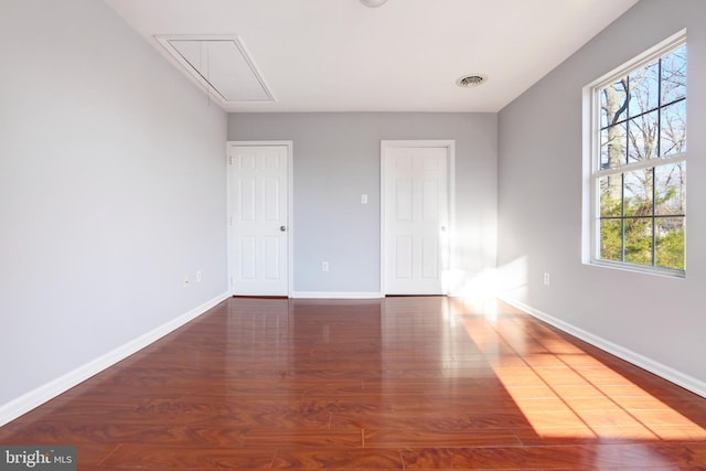 empty room with dark wood-type flooring and plenty of natural light