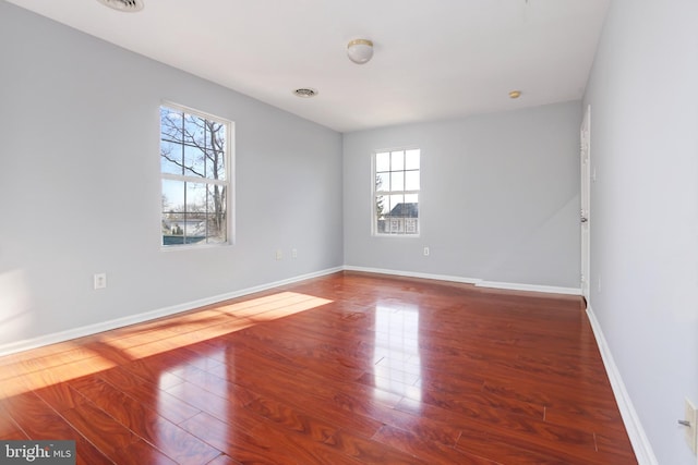 unfurnished room featuring wood-type flooring and a wealth of natural light