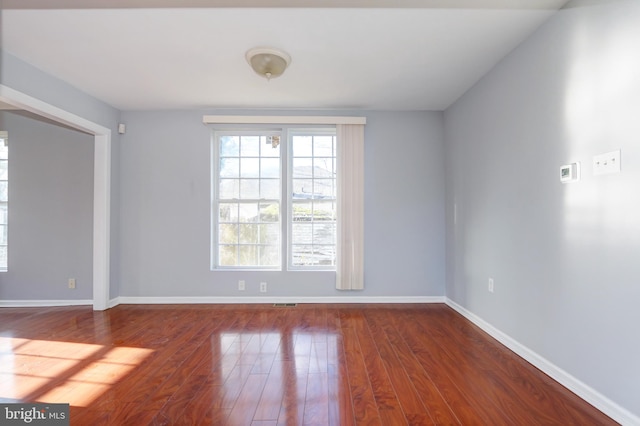 spare room featuring dark wood-type flooring