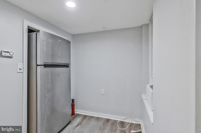 clothes washing area with baseboards and wood finished floors