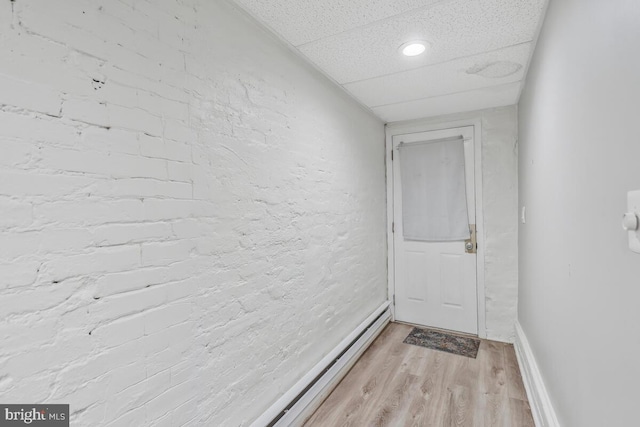 corridor featuring a paneled ceiling and light hardwood / wood-style flooring