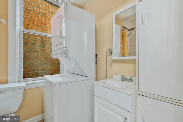 laundry room with stacked washer / dryer, brick wall, and sink