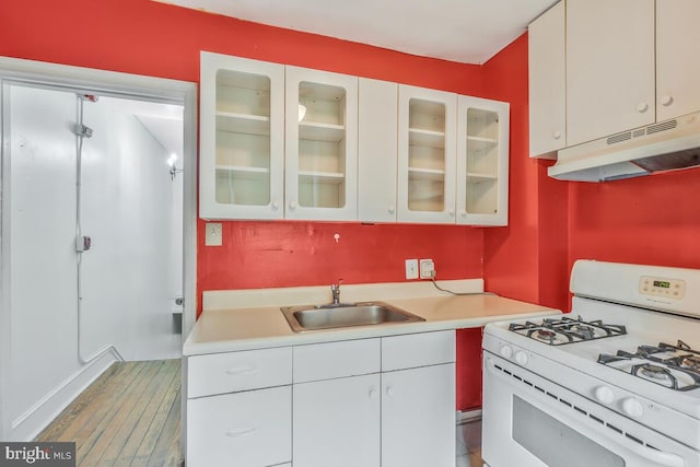 kitchen with sink, white cabinets, and white gas range oven