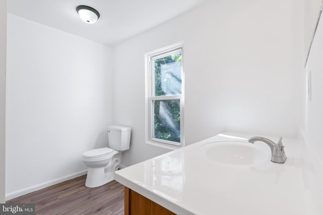 bathroom with vanity, toilet, and hardwood / wood-style floors