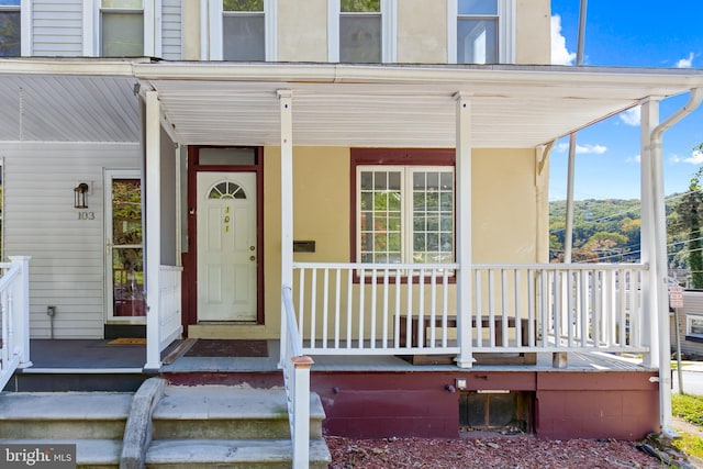 view of exterior entry featuring covered porch