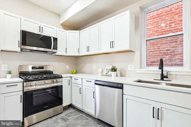 kitchen featuring sink, appliances with stainless steel finishes, and white cabinets