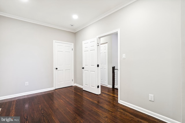 spare room with ornamental molding and dark hardwood / wood-style flooring