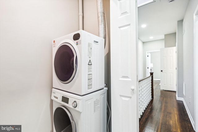 washroom with stacked washer / dryer and dark hardwood / wood-style flooring