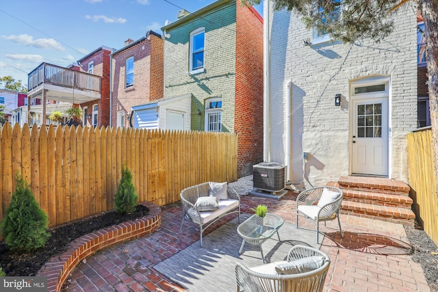 view of patio / terrace featuring central AC, outdoor lounge area, and a balcony