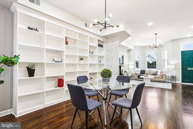 dining area featuring dark wood-type flooring and a notable chandelier