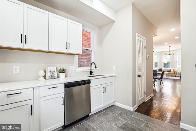 kitchen with white cabinets, an inviting chandelier, dishwasher, dark wood-type flooring, and sink