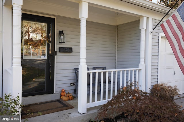 doorway to property with a garage and a porch