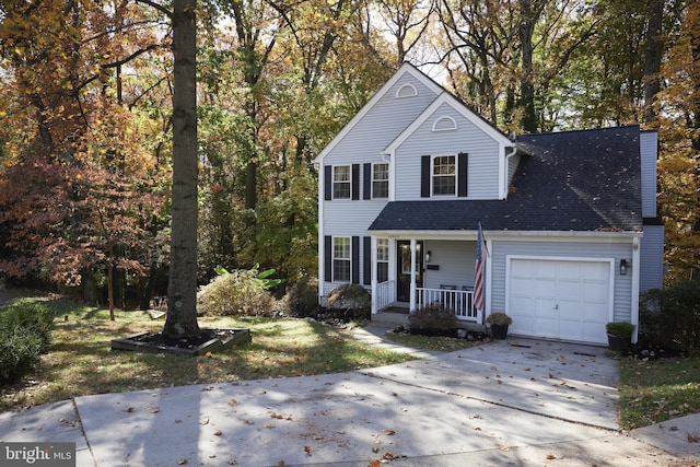 view of property with covered porch and a garage