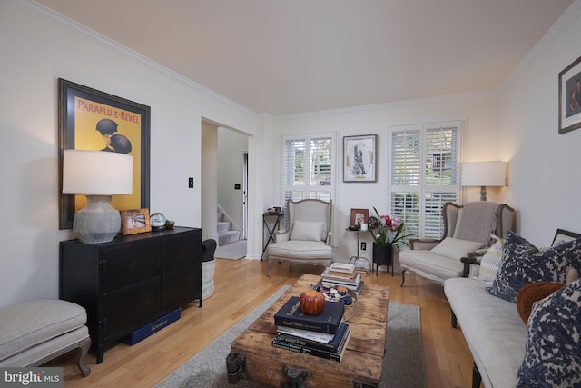 living room with light hardwood / wood-style floors and crown molding