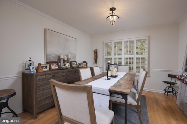 dining area featuring light hardwood / wood-style floors and crown molding