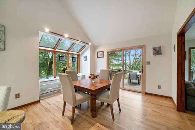 dining area with light hardwood / wood-style flooring and high vaulted ceiling