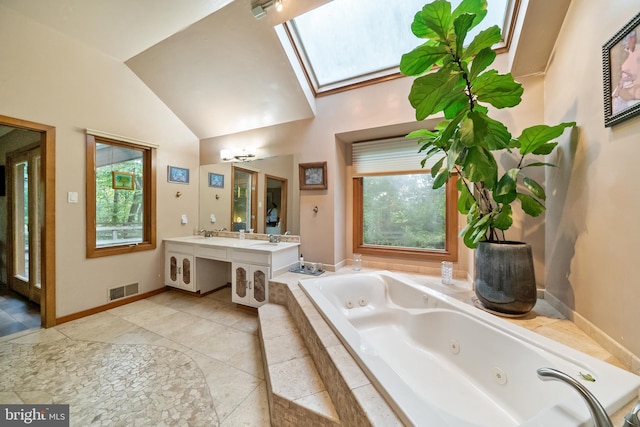 bathroom with vanity, lofted ceiling with skylight, tiled bath, and plenty of natural light