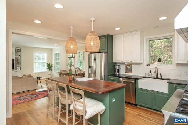 kitchen with sink, white cabinetry, light hardwood / wood-style flooring, and stainless steel appliances