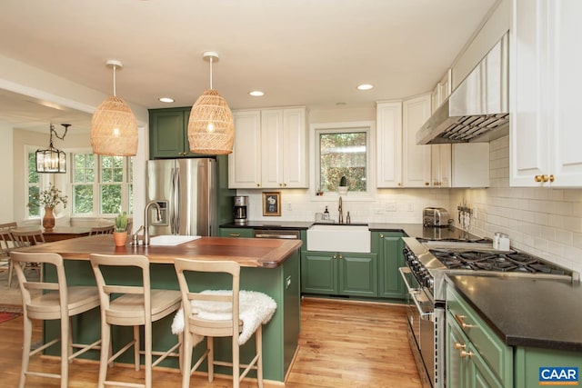 kitchen featuring a center island, white cabinetry, stainless steel appliances, and plenty of natural light