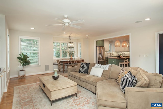 living room featuring light hardwood / wood-style floors and ceiling fan