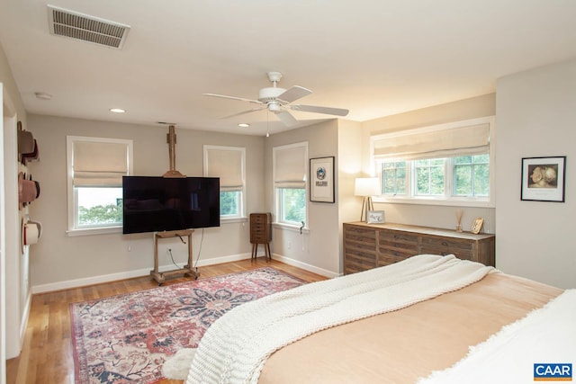 bedroom featuring light hardwood / wood-style flooring, multiple windows, and ceiling fan