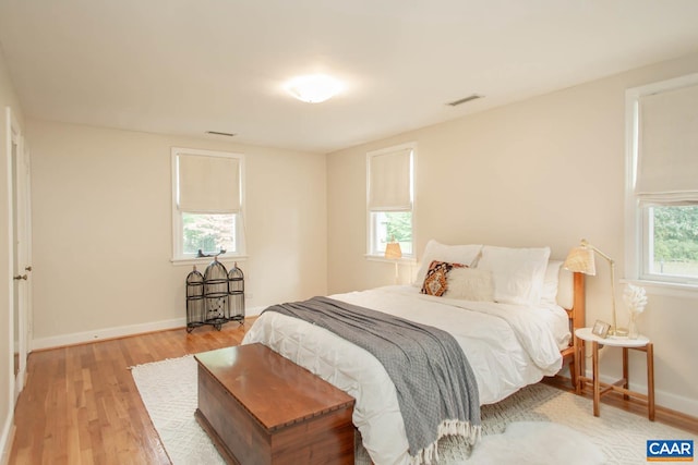 bedroom featuring light hardwood / wood-style flooring and multiple windows