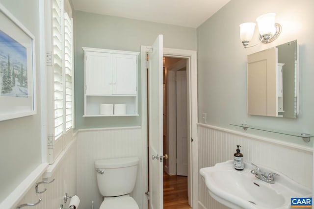 bathroom with toilet, sink, and hardwood / wood-style floors