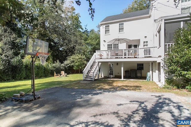 back of house with a wooden deck and a lawn