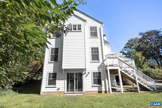 back of house with a yard and a wooden deck