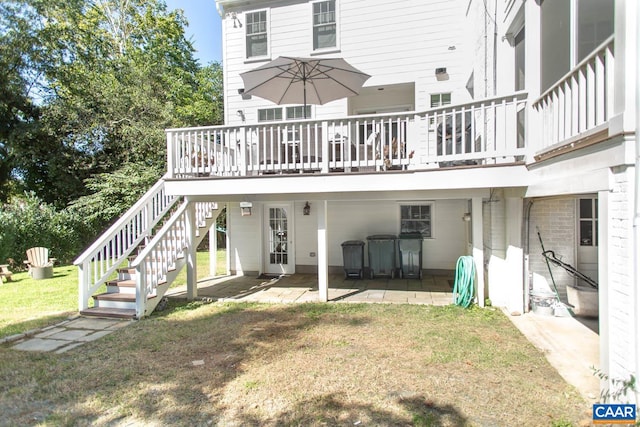 back of house with a wooden deck and a lawn