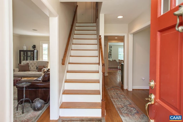 staircase featuring crown molding and wood-type flooring