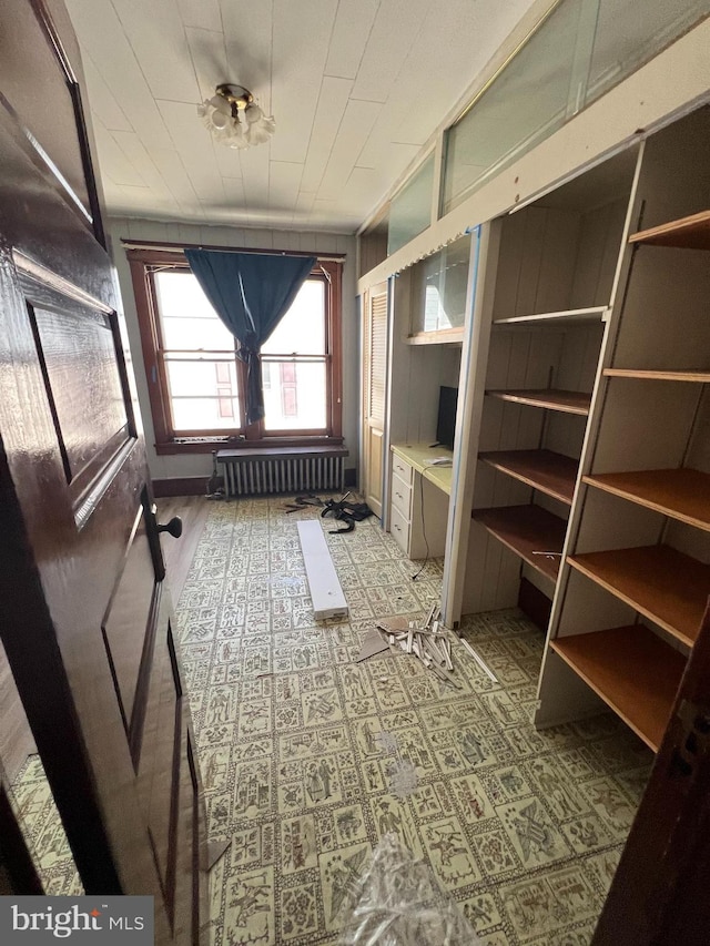 miscellaneous room featuring radiator heating unit and wooden walls