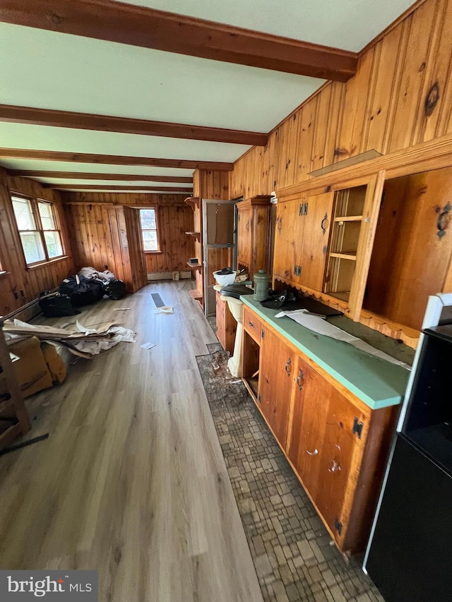 misc room featuring wood walls, beamed ceiling, and dark wood-type flooring