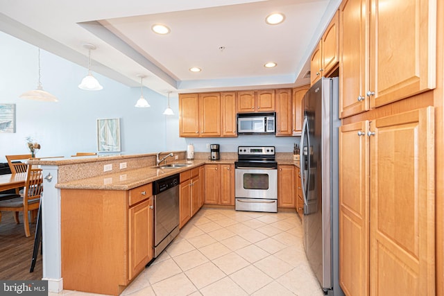 kitchen featuring kitchen peninsula, stainless steel appliances, hanging light fixtures, and sink